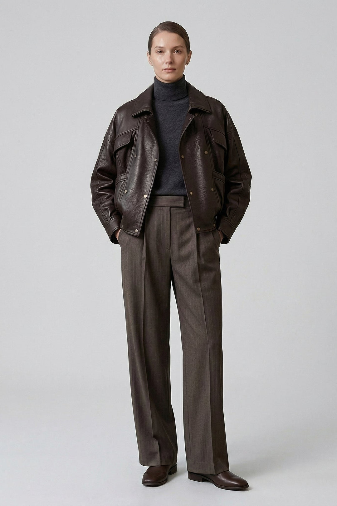 AINSLEY - Model wearing brown leather jacket and patterned trousers