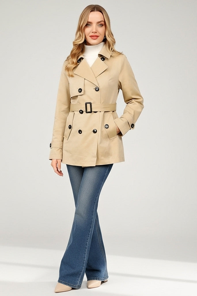 ALVERA - Woman wearing a beige trench coat and blue jeans on a white background