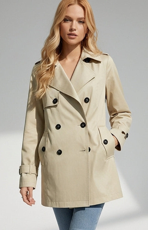 ALVERA - Woman wearing a beige trench coat with black buttons on a gray background