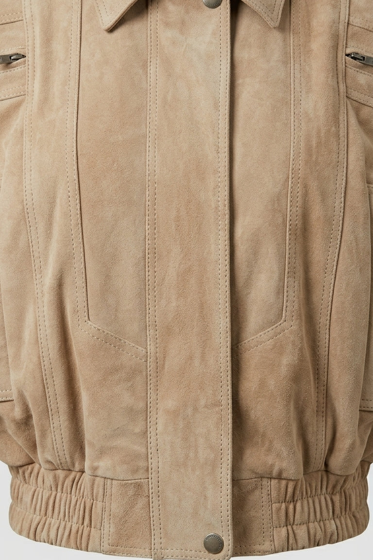 ANNE - Close-up of a beige jacket front-closure with a plain background