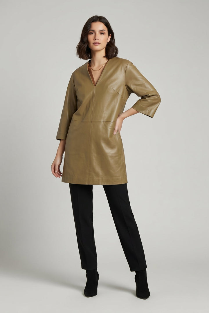 AUDREY - Woman wearing a green leather dress with black pants on a plain background