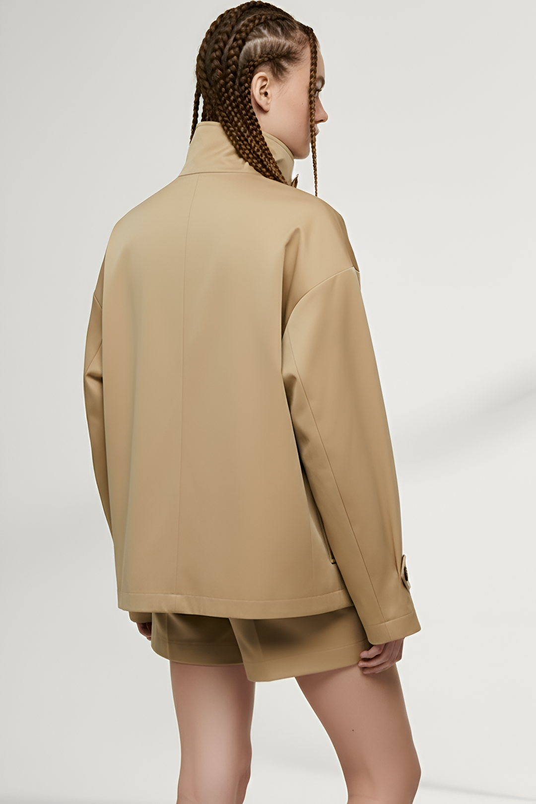 Back view of ENVARA waterproof trench coat showing long silhouette and clean seams.