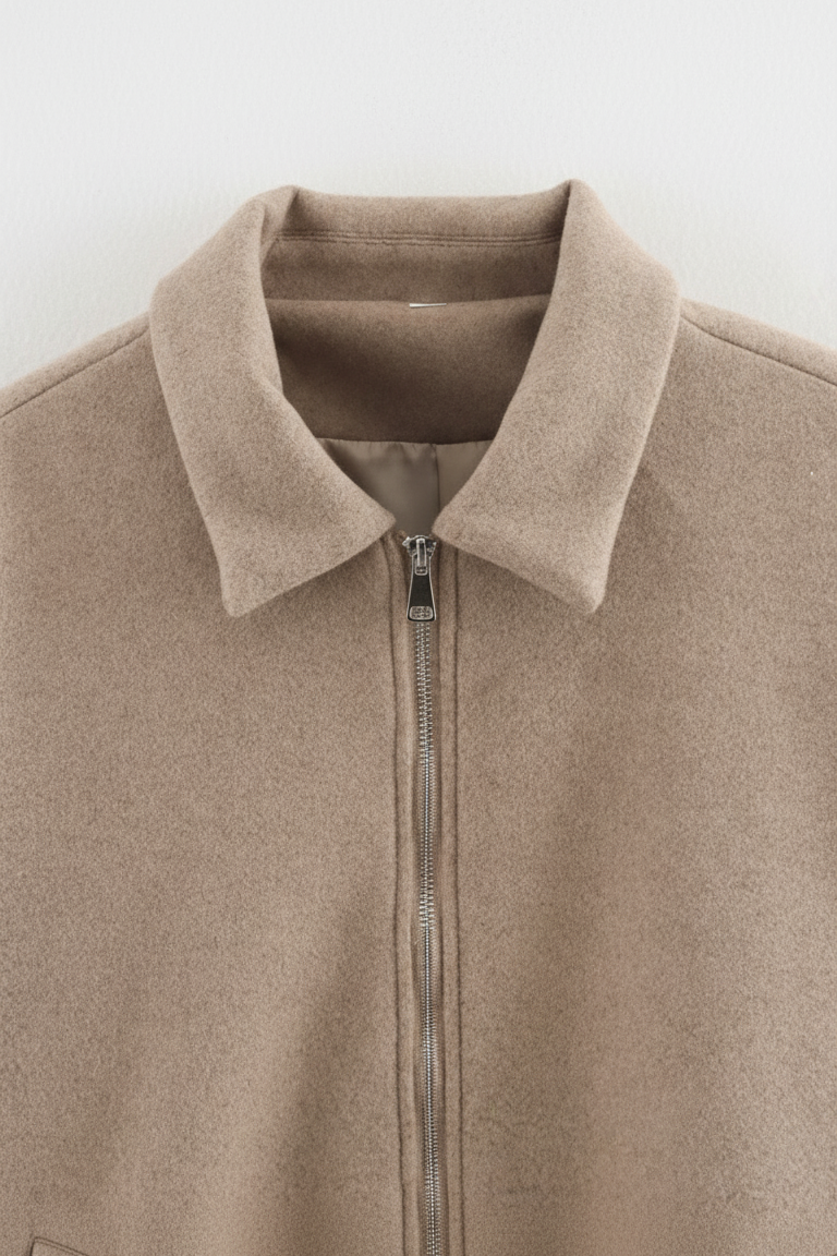 Beige jacket with a collar and zipper on a light gray background