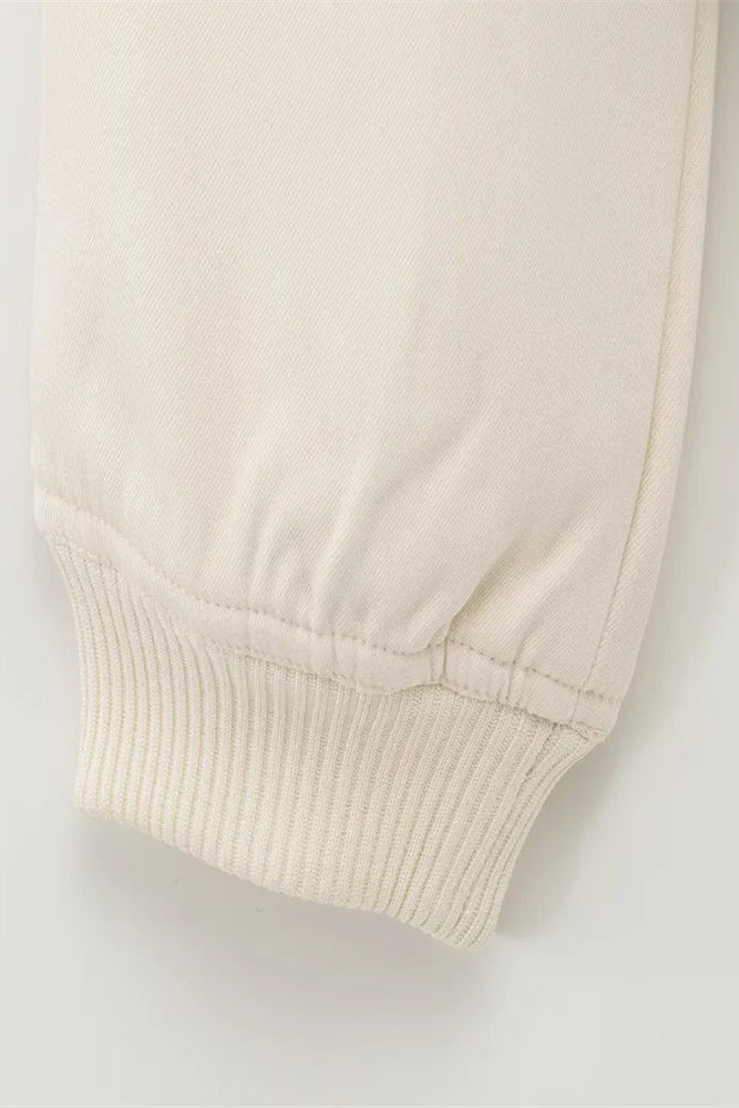 Beige ribbed sweater sleeve on a light gray background