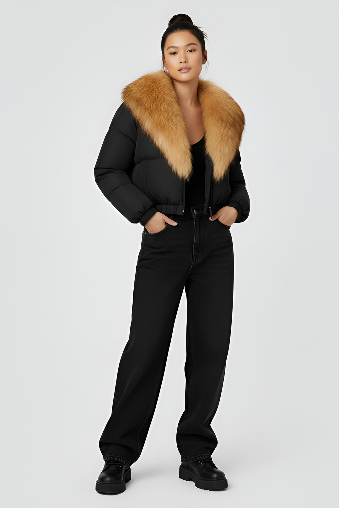 Black puffer jacket with brown fur collar on a light gray background