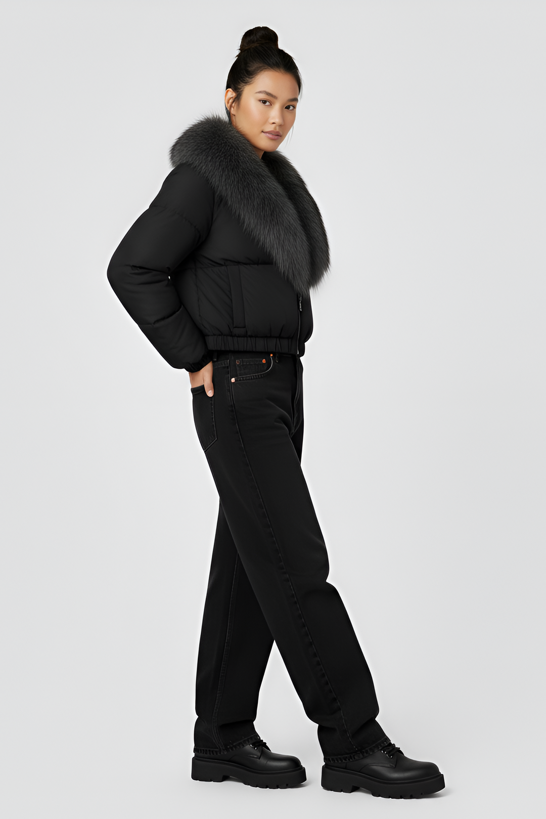 Black puffer jacket with gray fur collar on a light gray background