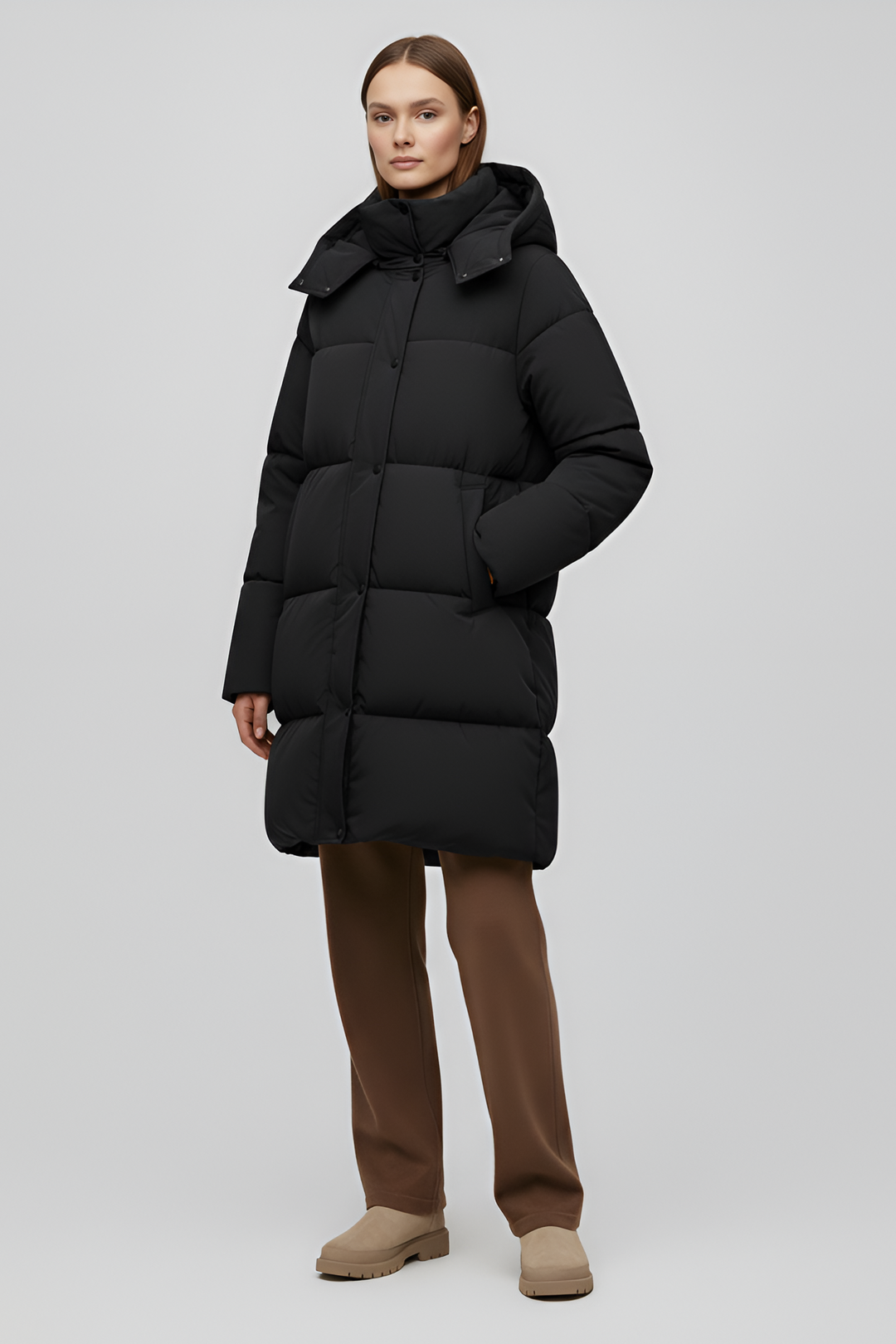 Person wearing a black puffer coat against a white background