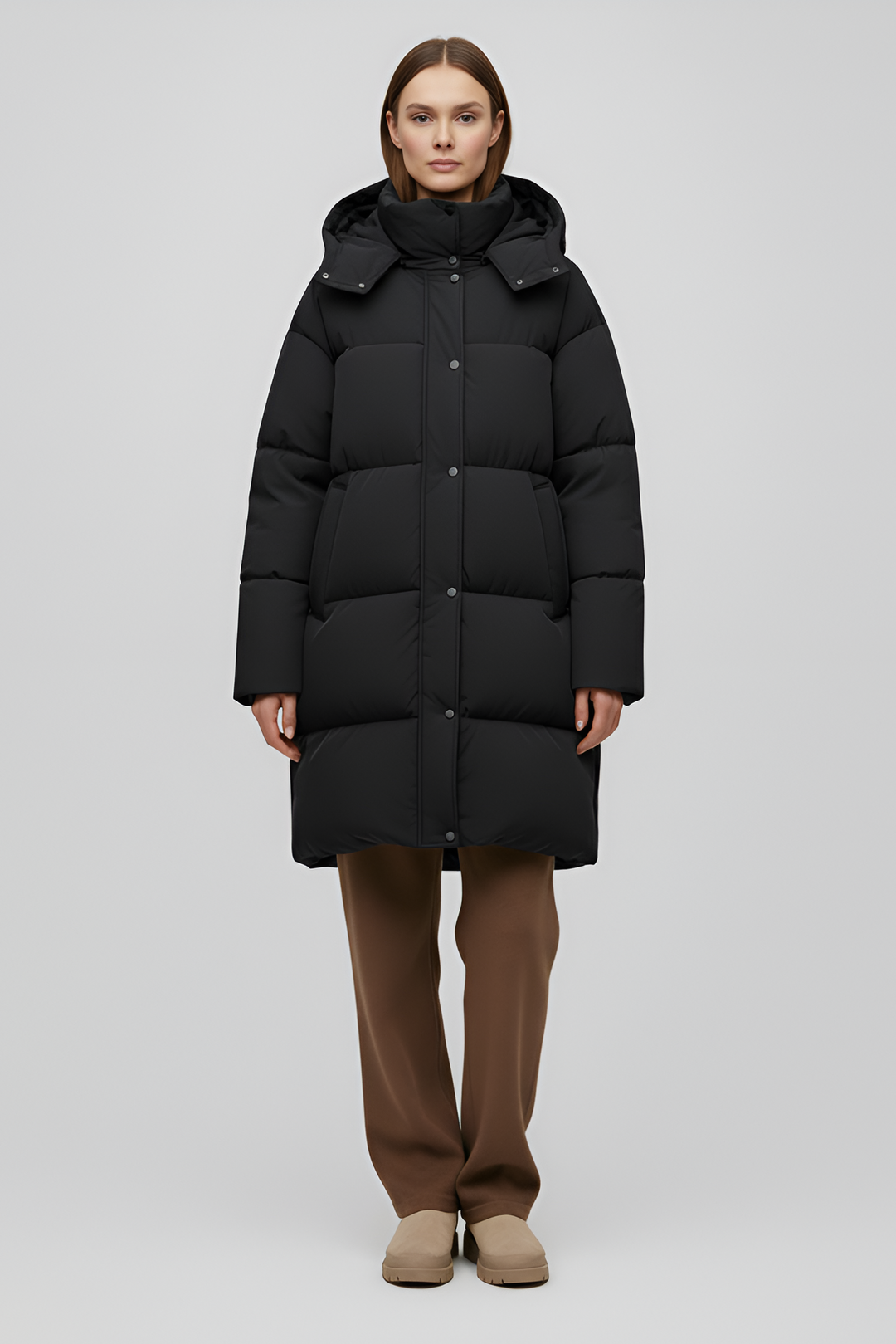 Person wearing a black puffer coat against a white background