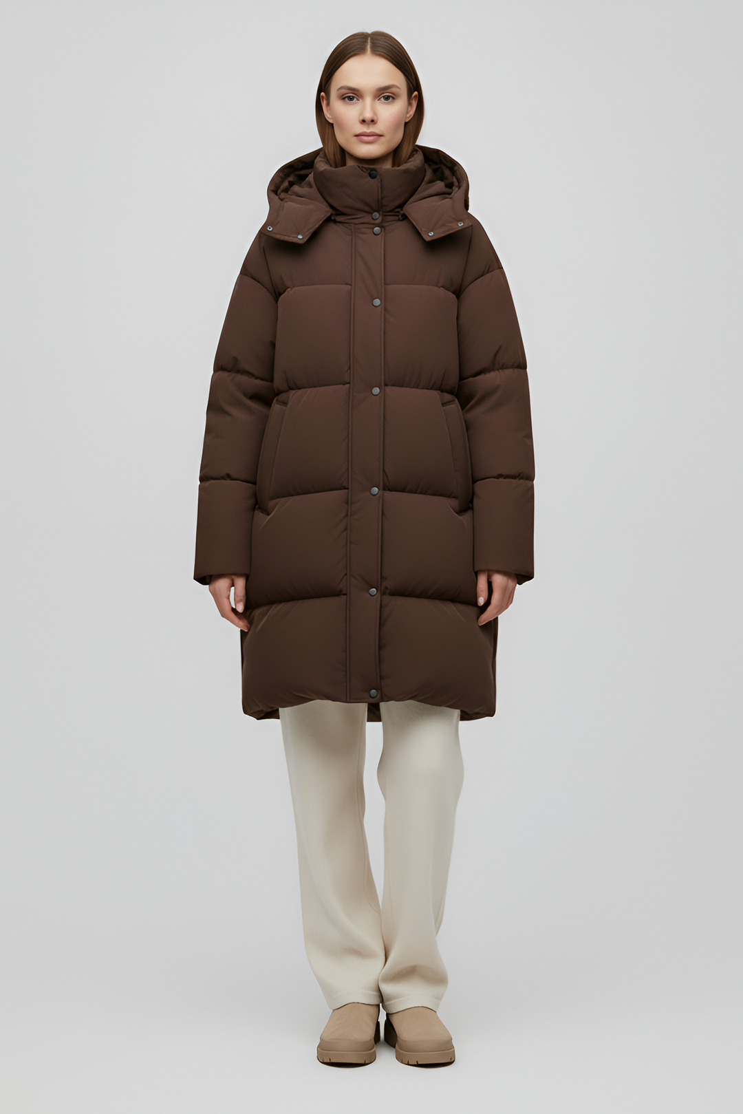 Person wearing a brown puffer coat on a white background