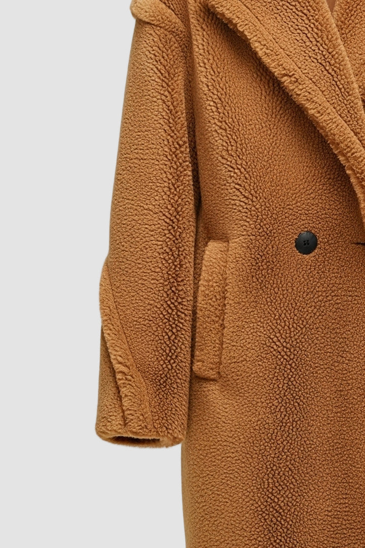 Brown coat with a close-up of the collar and button on a light gray background