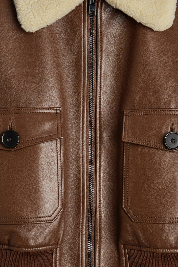 Brynne - Close-up of brown jacket zipper and chest pockets