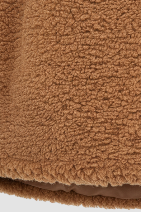 Chic women’s brown faux fur coat with long hair texture front view.