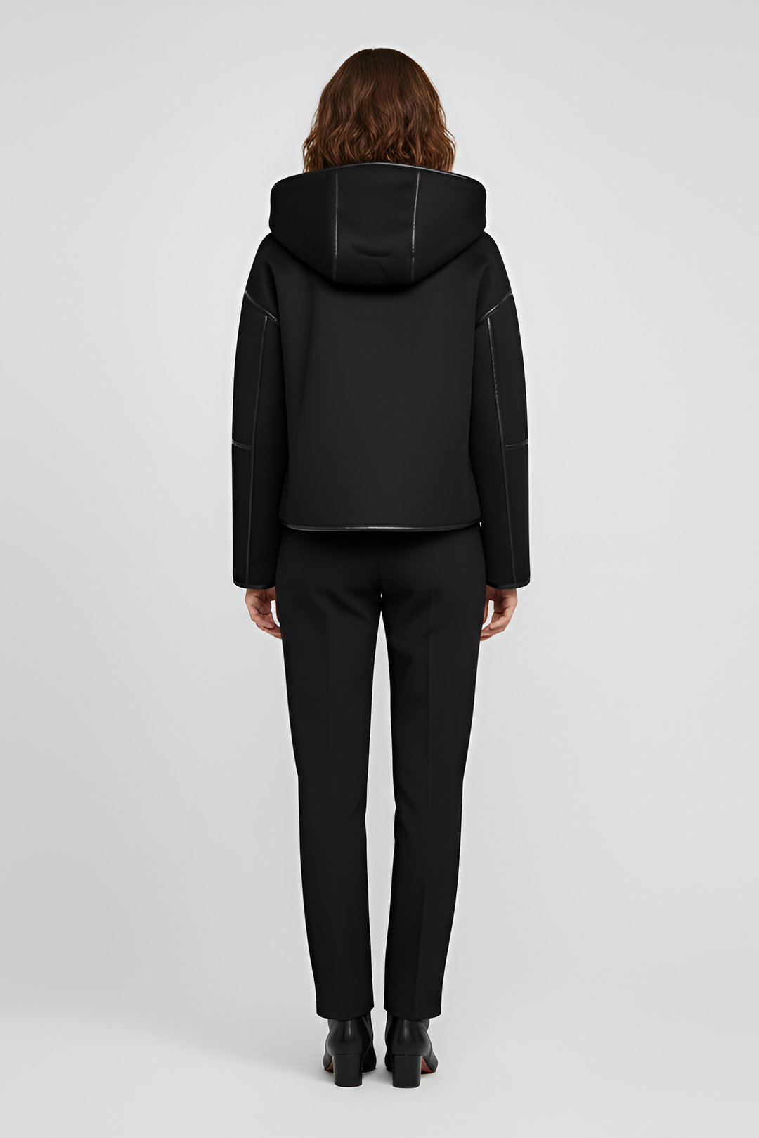 Close-up of YALVINE coat showing faux fur details, zipper, and button accents.