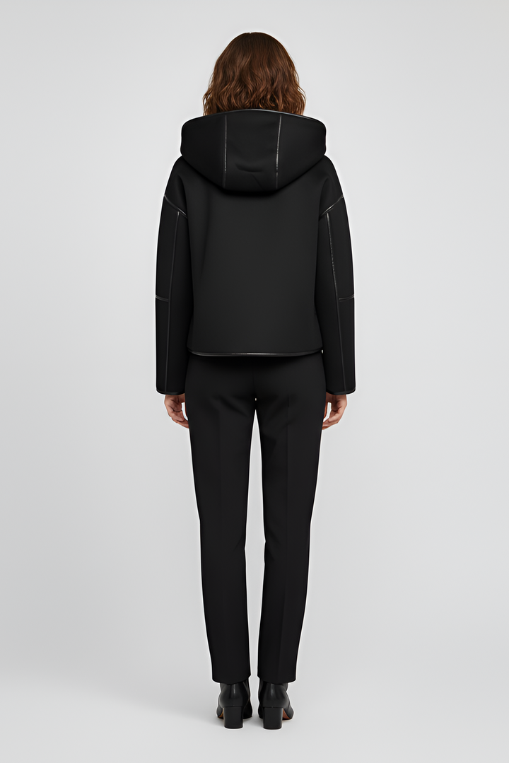 Close-up of YALVINE coat showing faux fur details, zipper, and button accents.