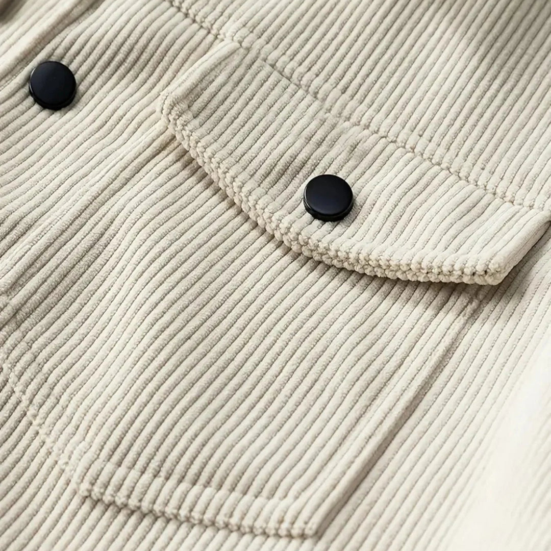 Close-up of a beige corduroy jacket with black buttons on a white background