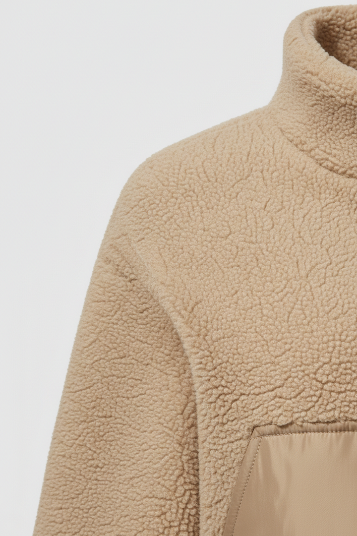 Close-up of a beige fleece jacket on a light gray background