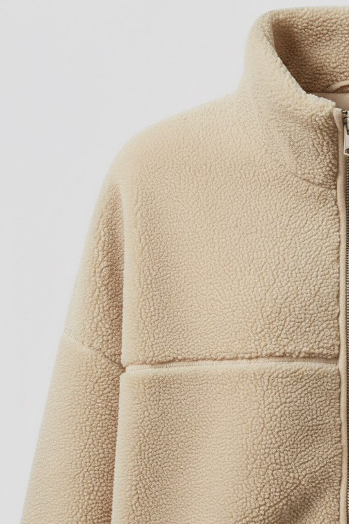 Close-up of a beige fleece jacket on a light gray background