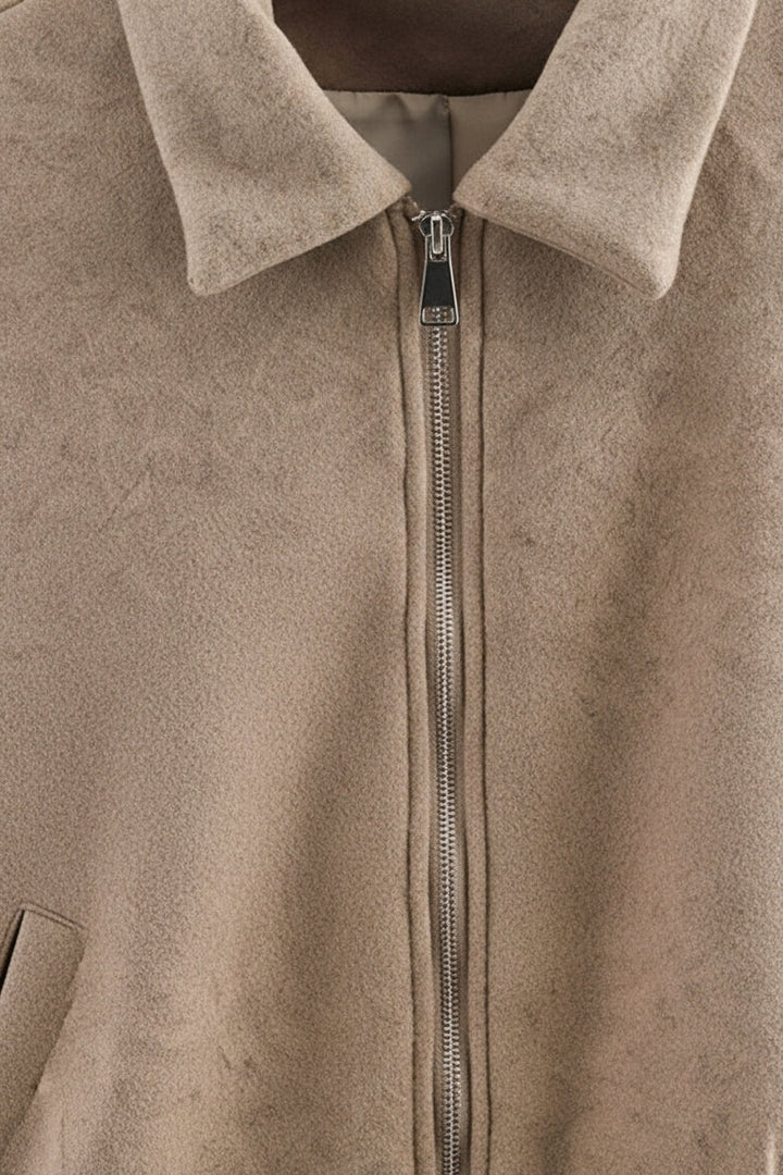 Close-up of a beige jacket with a zipper