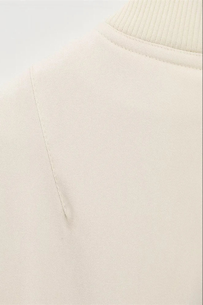 Close-up of a beige sweater on a light gray background