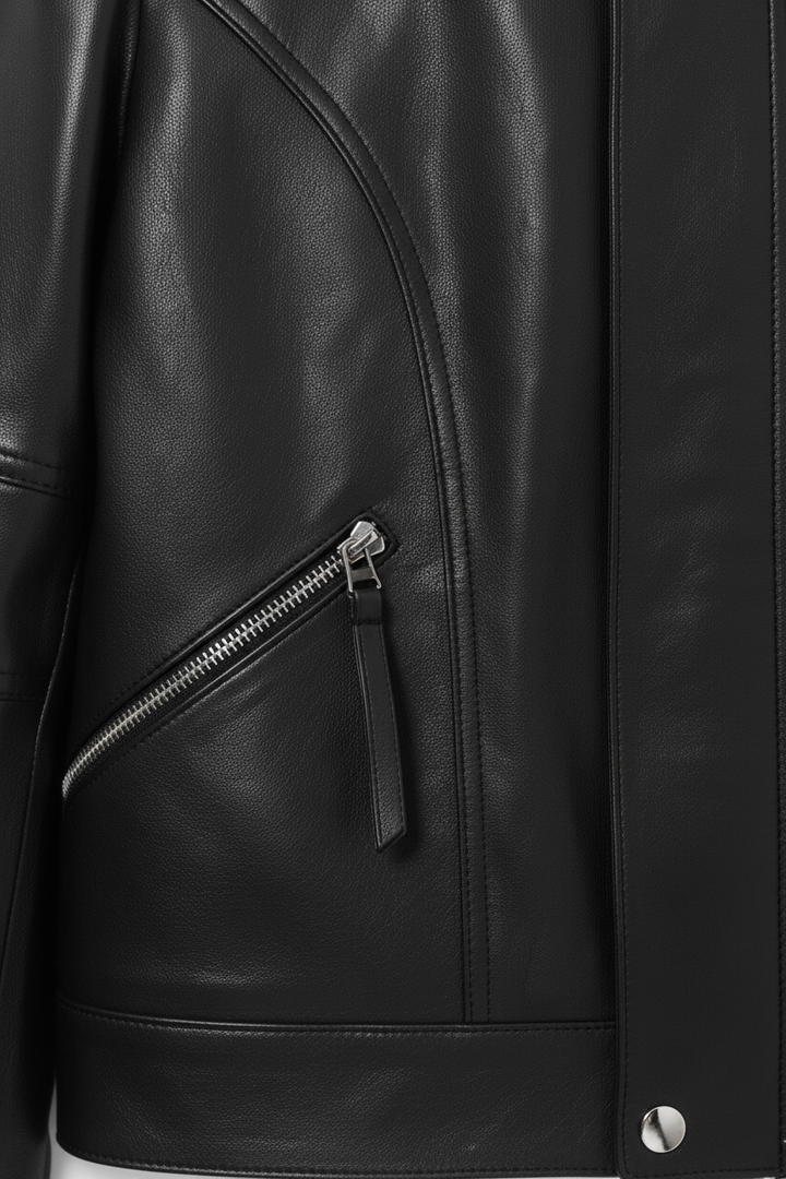 Close-up of a black leather jacket with a zipper detail.