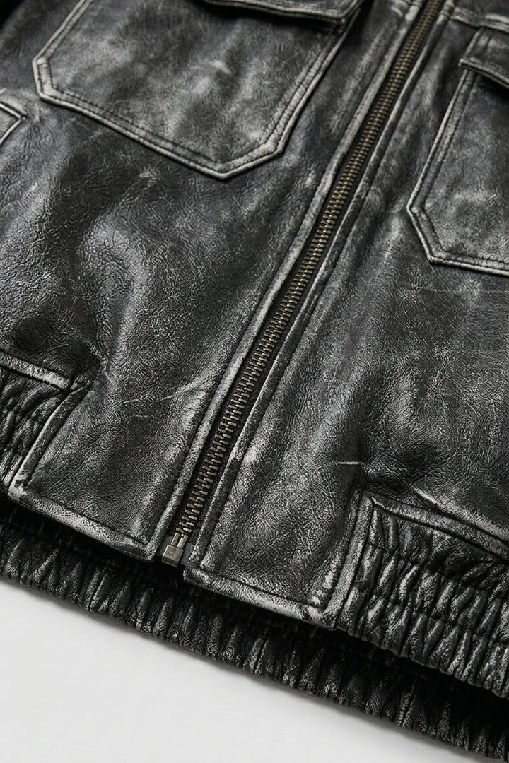 Close-up of a black leather jacket with zippers and pockets on a white background
