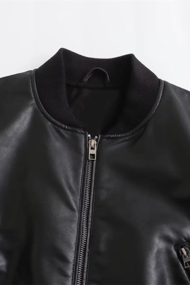 Close-up of a black leather jacket with zippers on a light gray background