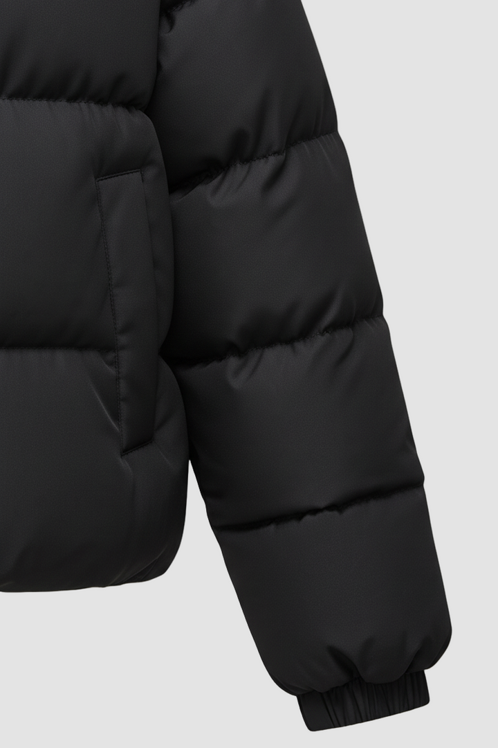 Close-up of a black puffer jacket on a white background