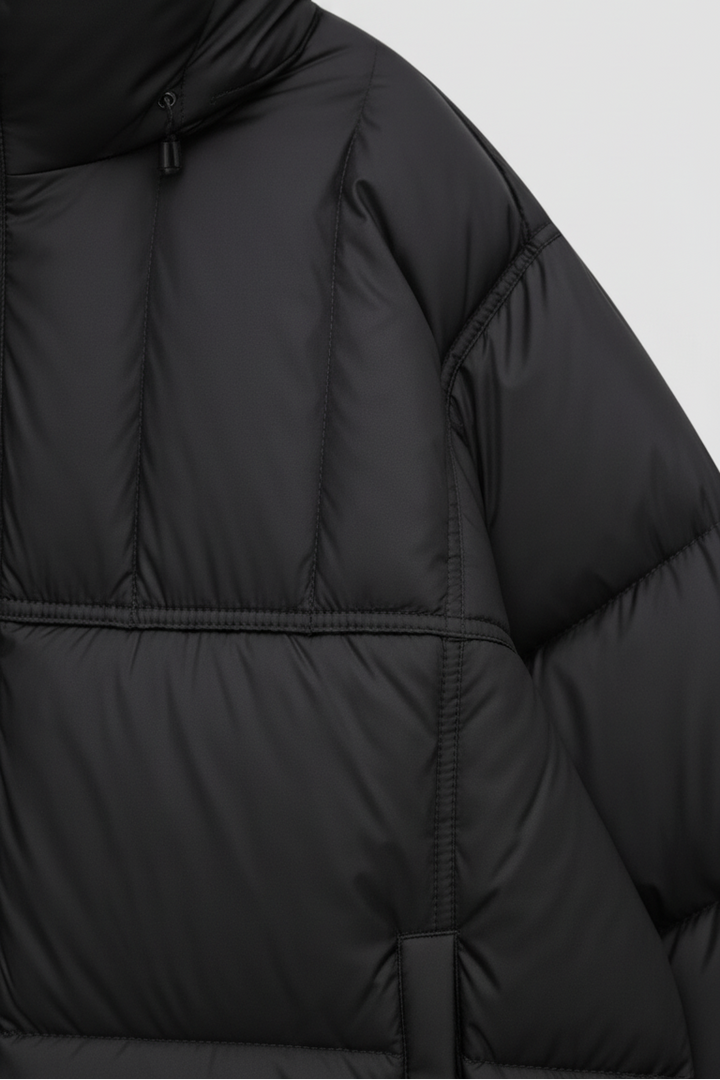 Close-up of a black puffer jacket on a light gray background