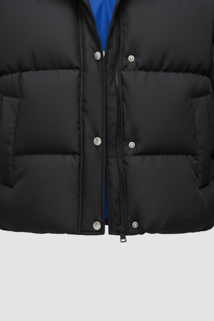 Close-up of a black puffer jacket with blue lining on a white background