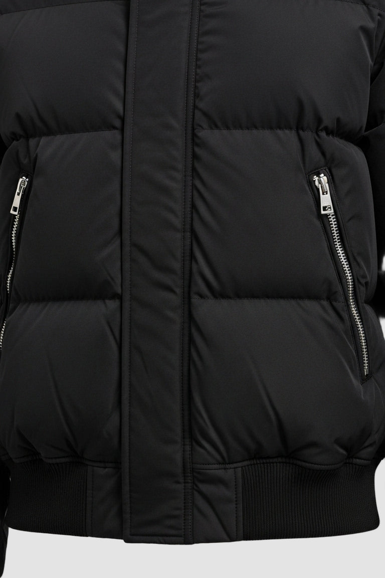 Close-up of a black puffer jacket with zippers on a white background