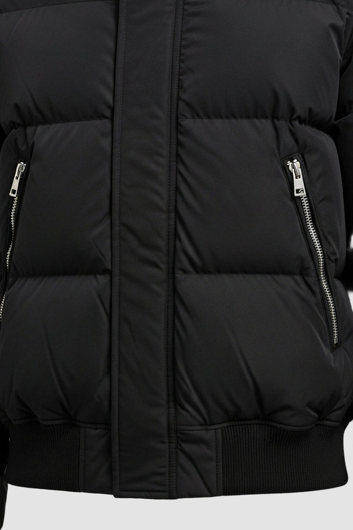Close-up of a black puffer jacket with zippers on a white background