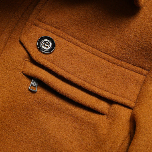 Close-up of a brown coat with a button and zipper detail