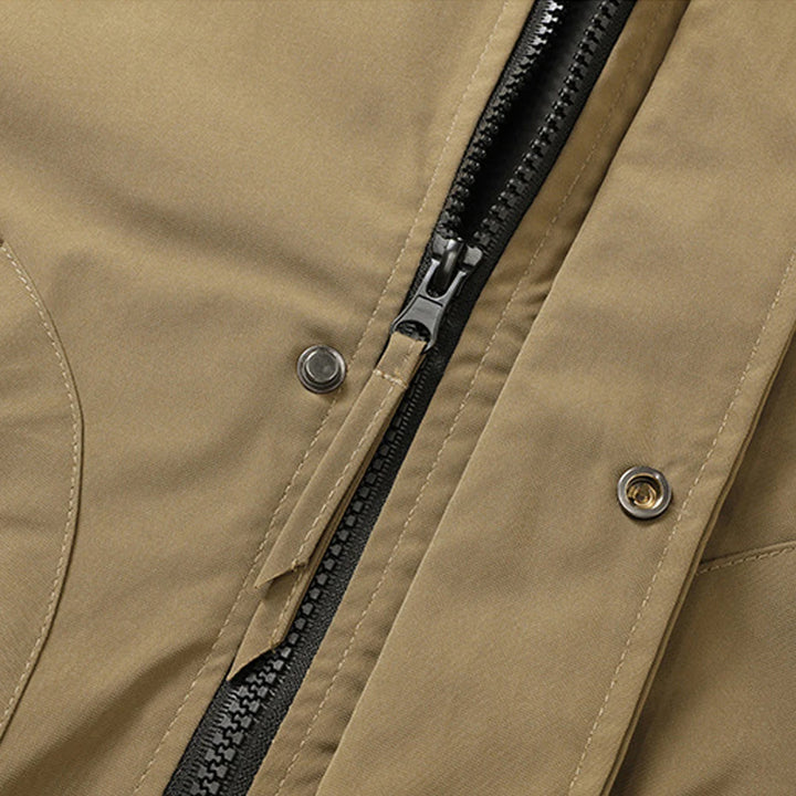 Close-up of a brown jacket with a black zipper and buttons.