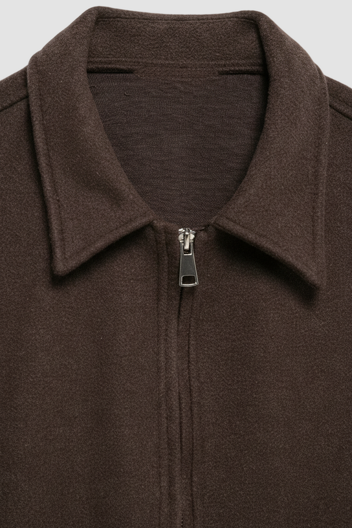 Close-up of a brown zip-up garment with a collar on a white background