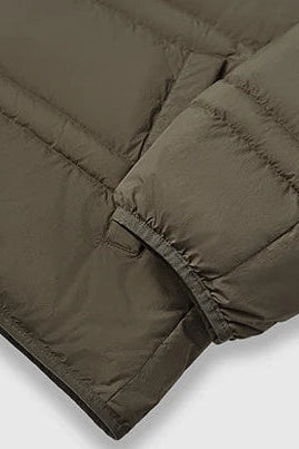 Close-up of a dark brown puffer jacket with quilted design on a light gray background.