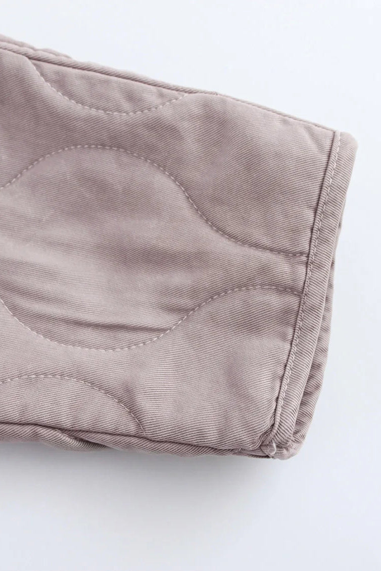 Close-up of a folded beige fabric on a white background