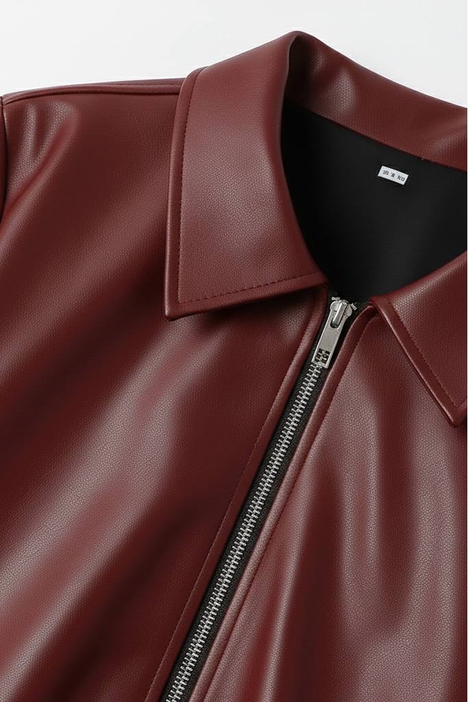 Close-up of a maroon leather jacket with a zipper on a white background