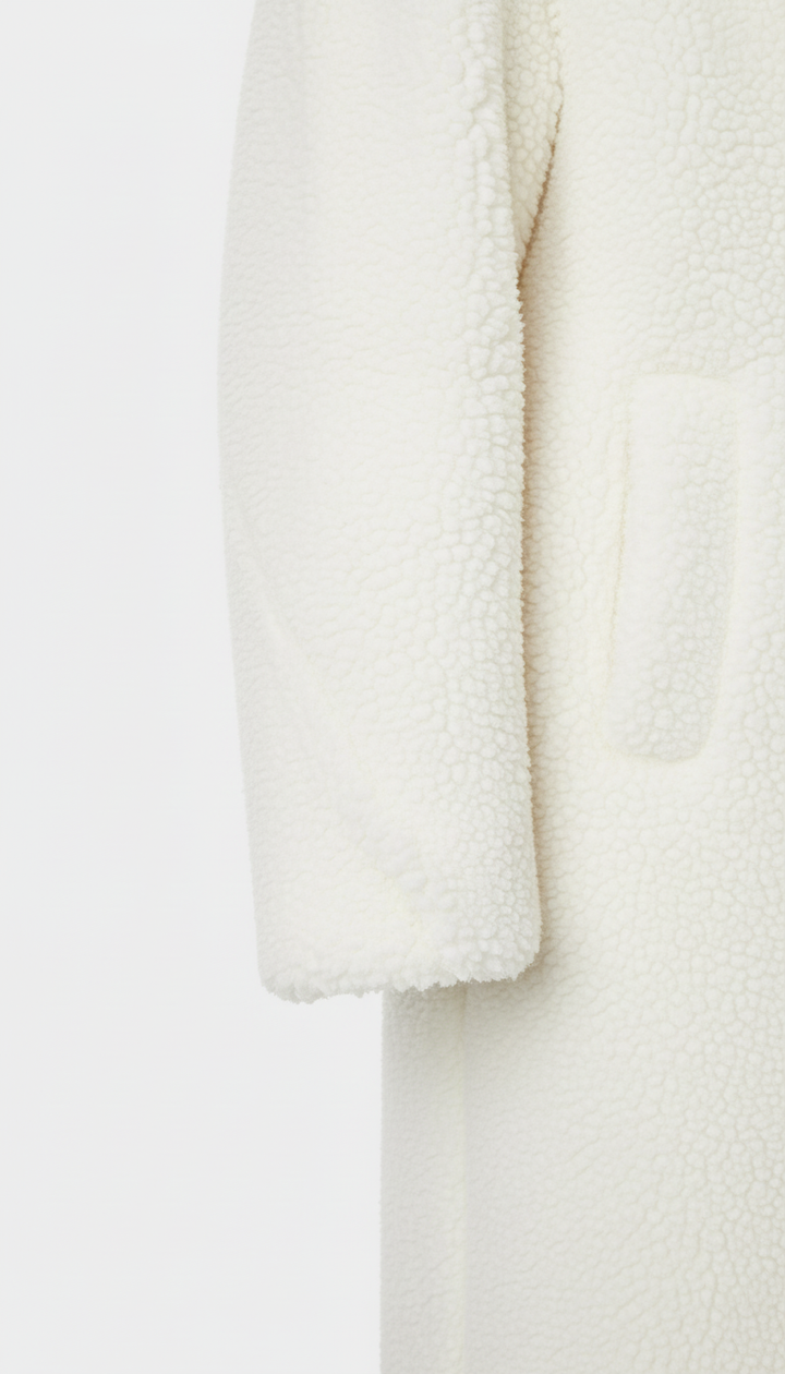 Close-up of a textured white garment on a light gray background