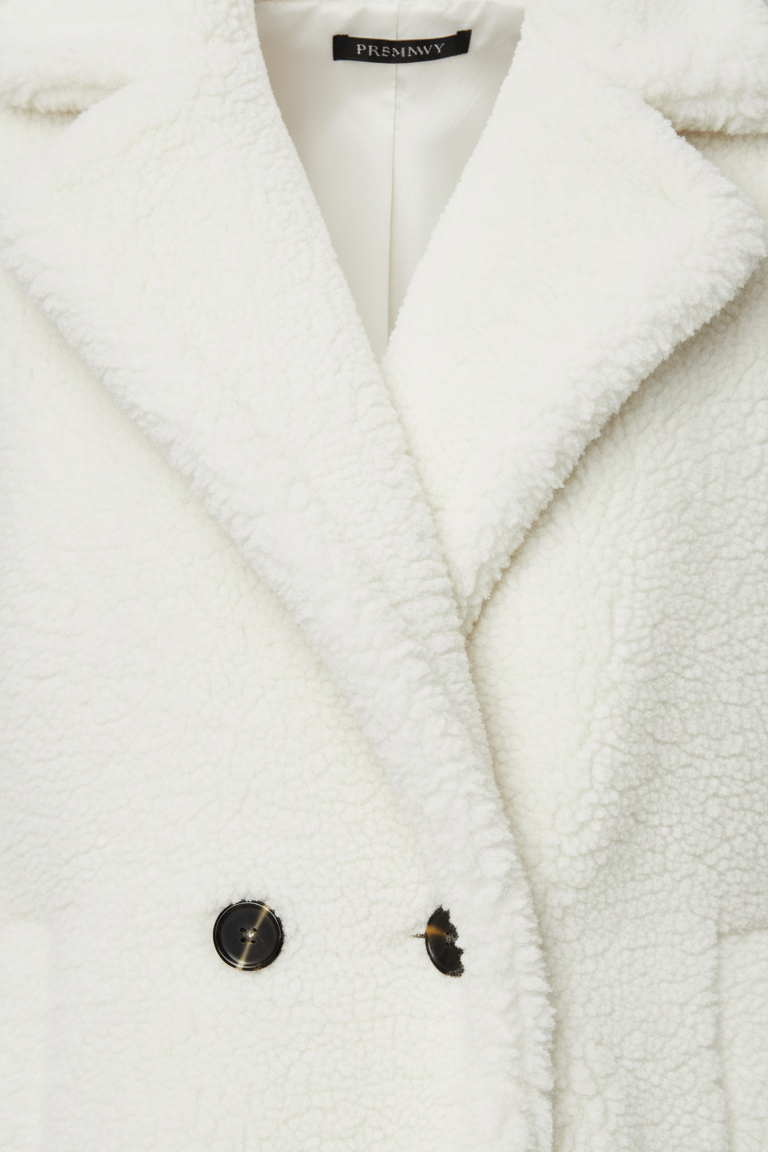 Close-up of a white coat with buttons on a light gray background