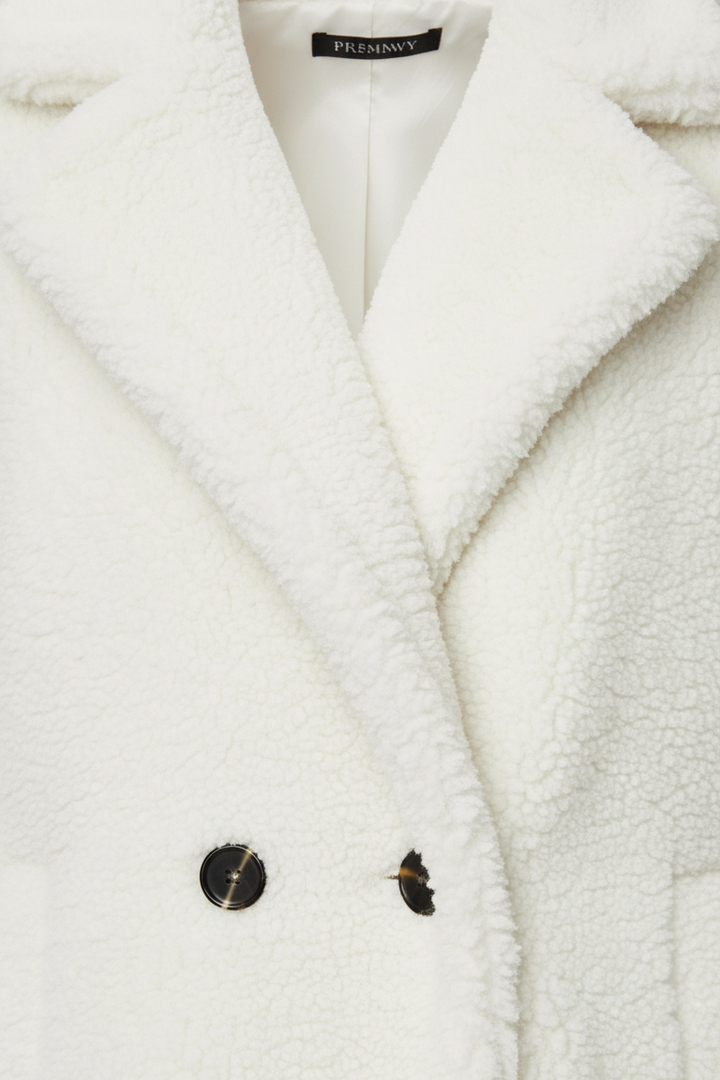 Close-up of a white coat with buttons on a light gray background