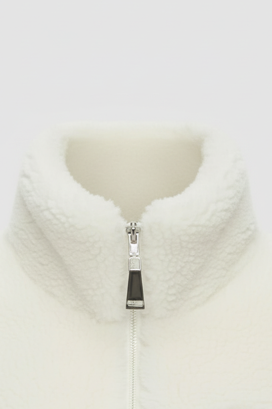 Close-up of a white fleece jacket with a zipper on a light gray background