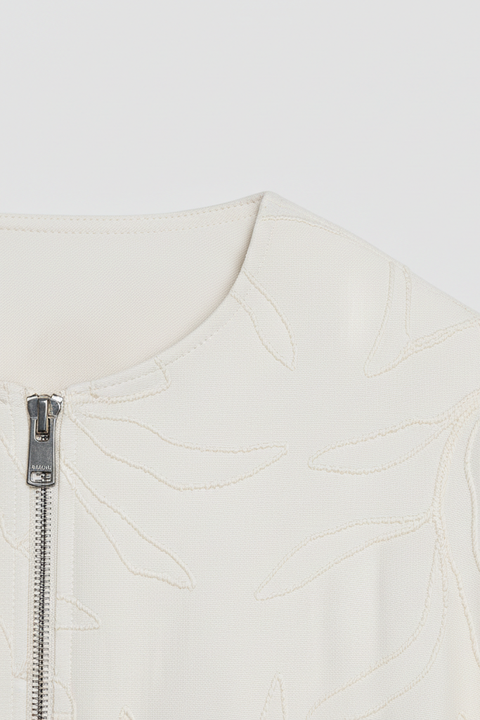 Close-up of a white jacket with a zipper on a light gray background