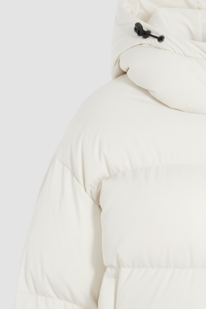 Close-up of a white puffer jacket with a hood on a white background