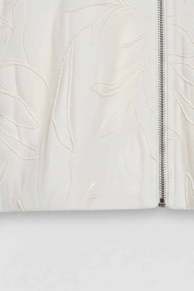 Close-up of a white textured fabric with a zipper