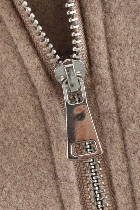 Close-up of a zipper on a brown fabric background