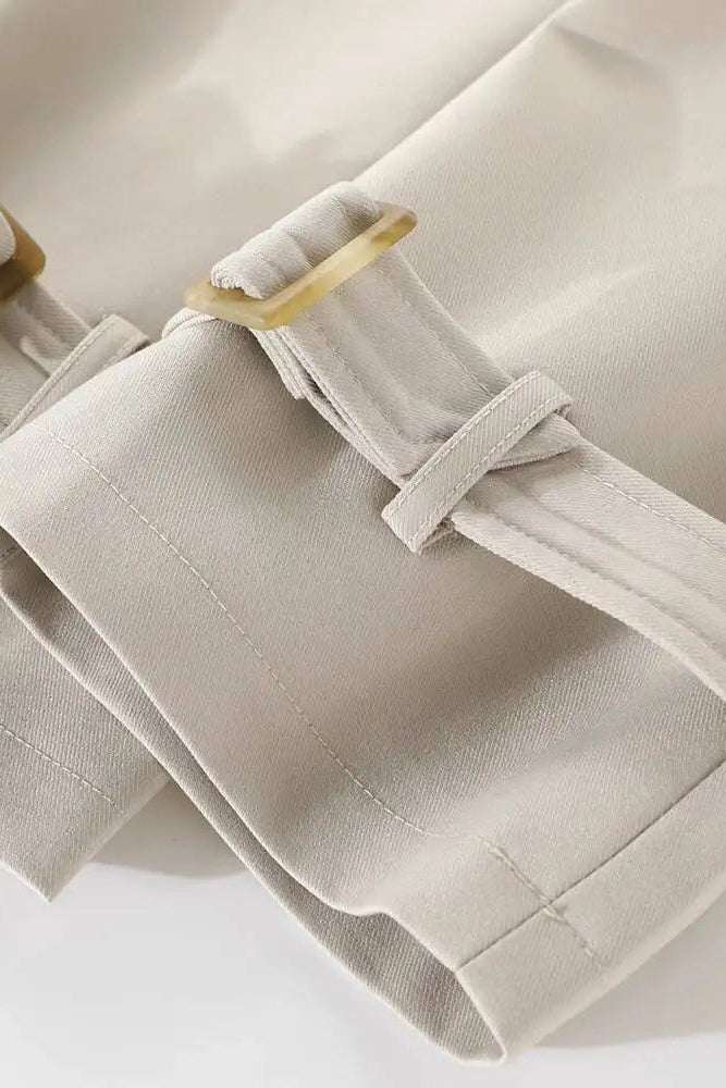 Close-up of beige pants with a buckle on a white background