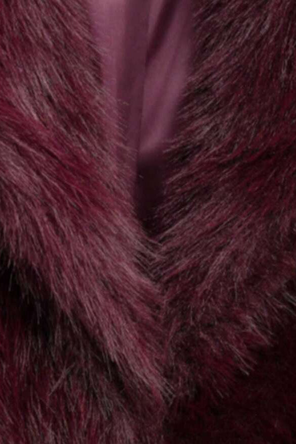 Close-up of the plush faux fur texture and wide collar of the Camelia winter coat in deep burgundy.