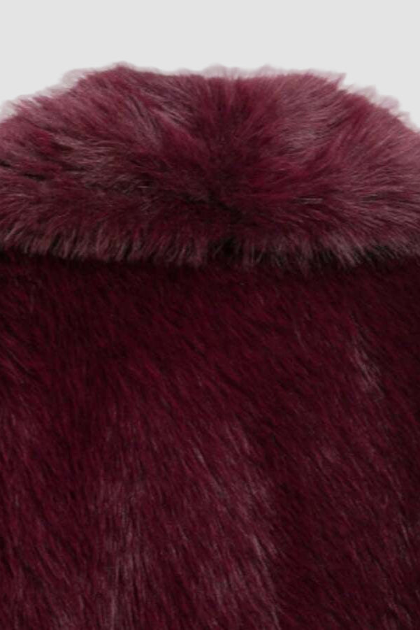 Close-up of the plush faux fur texture and wide collar of the Camelia winter coat in deep burgundy.