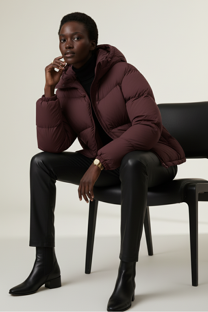 Close-up portrait of model in LYORE Down Jacket showing matte texture, zip front, and hood detail.