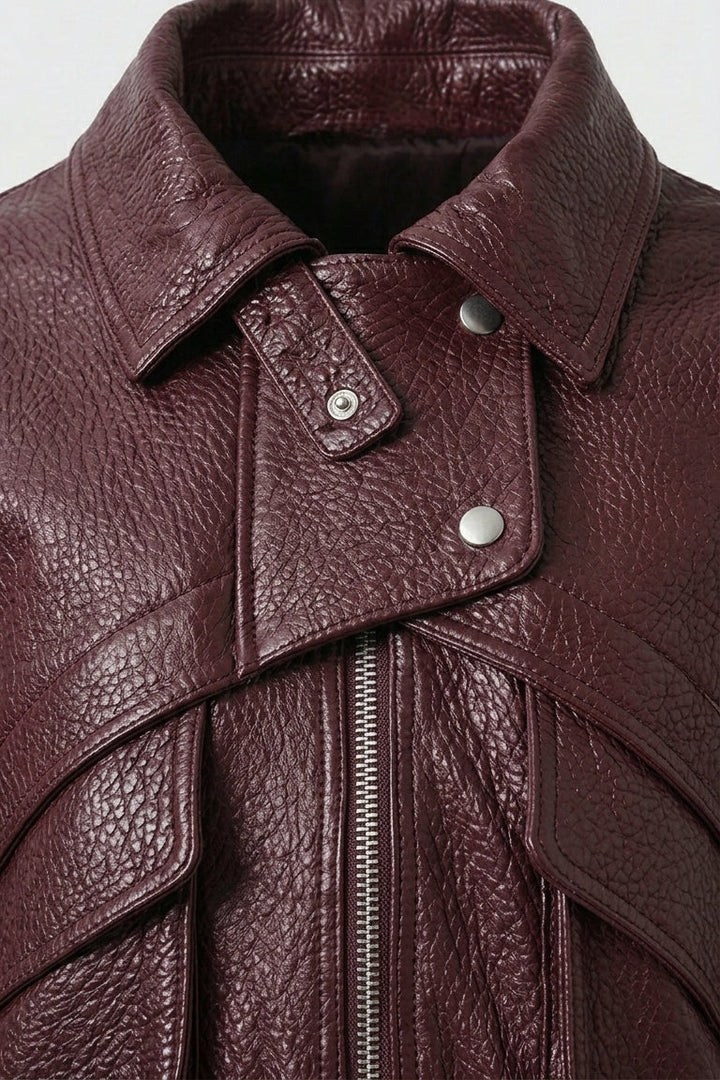 DREW - Close-up of a brown leather jacket collar and buttons with a zipper on a light gray background